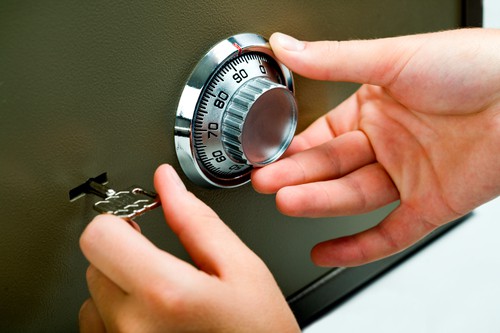 A business man opens his metal safe